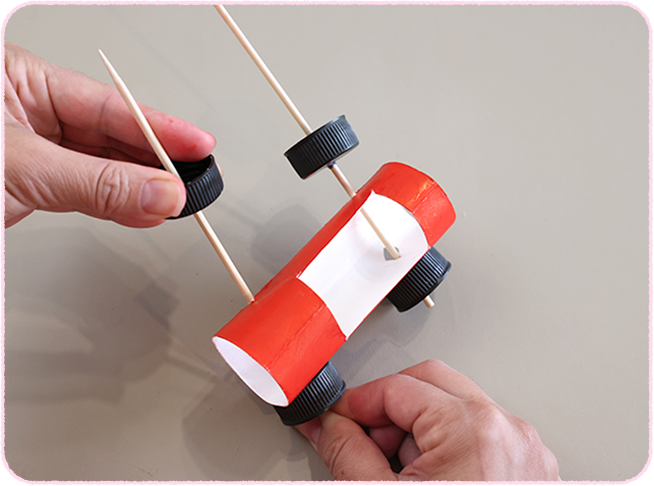 黒いキャップの穴に竹串を通し、車に刺して、反対側にもキャップを通す。竹串をちょうどいい長さで切る。